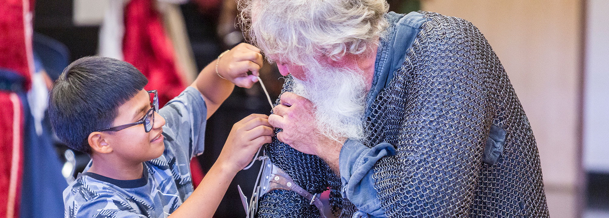 boy helping adult mend his costume