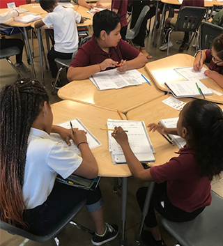 Students working on classwork at a table together