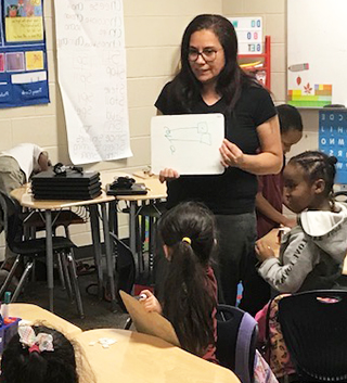 Teacher working with happy students in the classroom